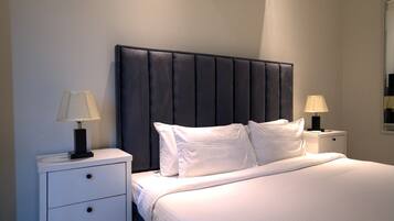 A hotel room with a bed, two bedside tables, and a headboard.