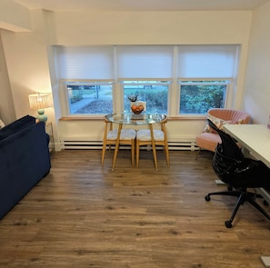 A compact living space with a round glass table, two chairs, a sofa, a desk, and a chair. - 1BR/1BA in Andersonville · pet-friendly · workspace · garage parking · king bed (Chicago)