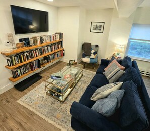 Un saló amb una biblioteca, un sofà, una taula de centre i una televisió.
