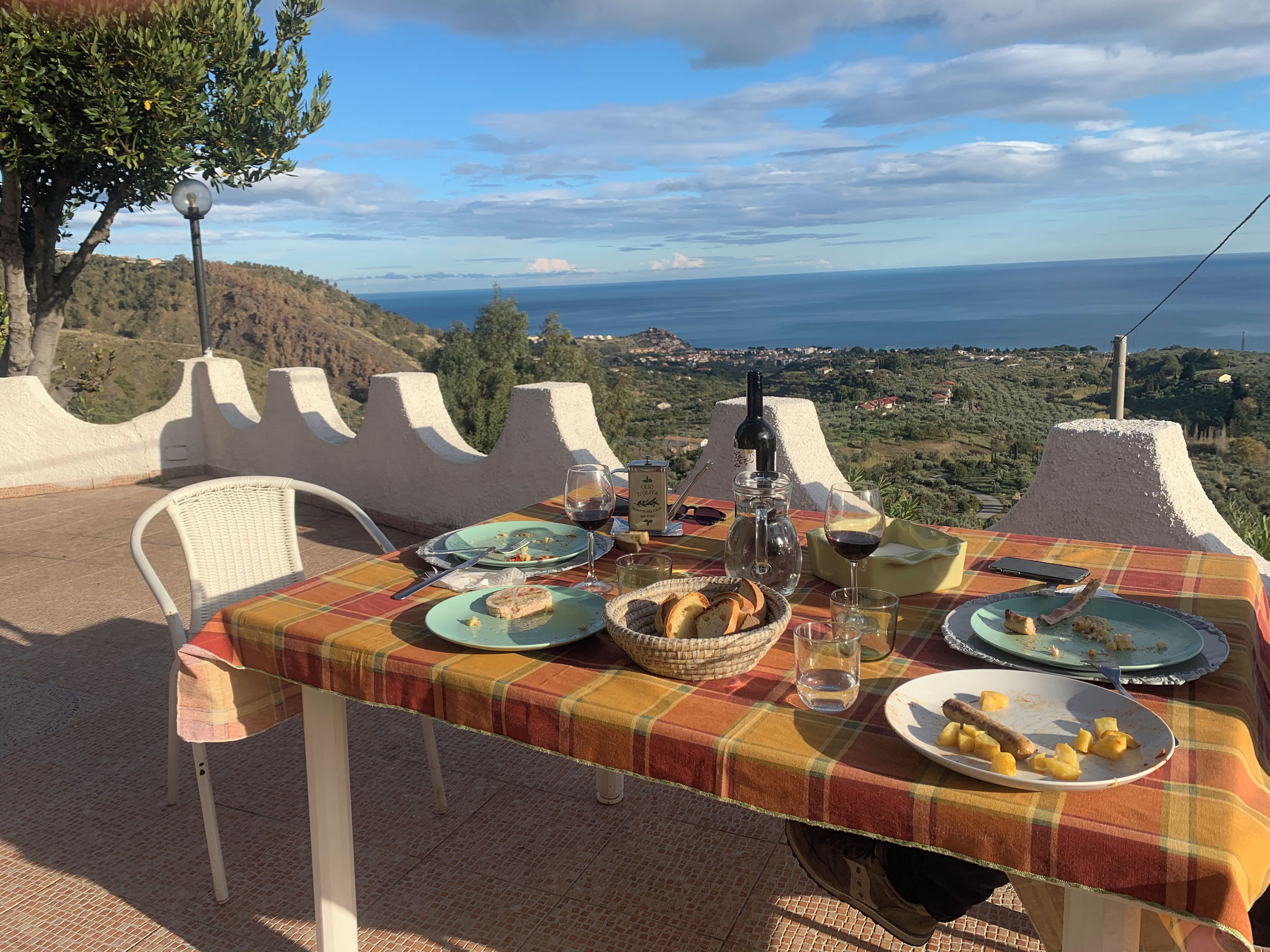 Taula a l'aire lliure amb vista al mar i a les muntanyes.