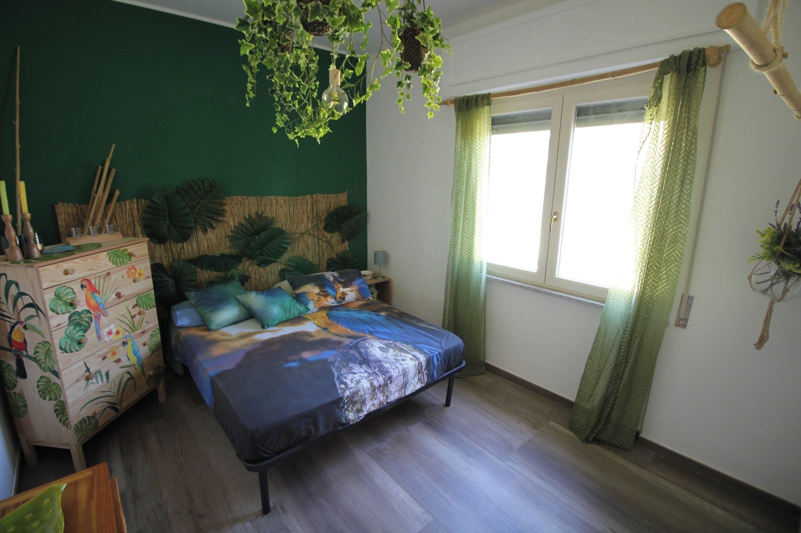 Ein Schlafzimmer mit einem Bett, einem Schminktisch und einem Fenster mit Vorhängen.