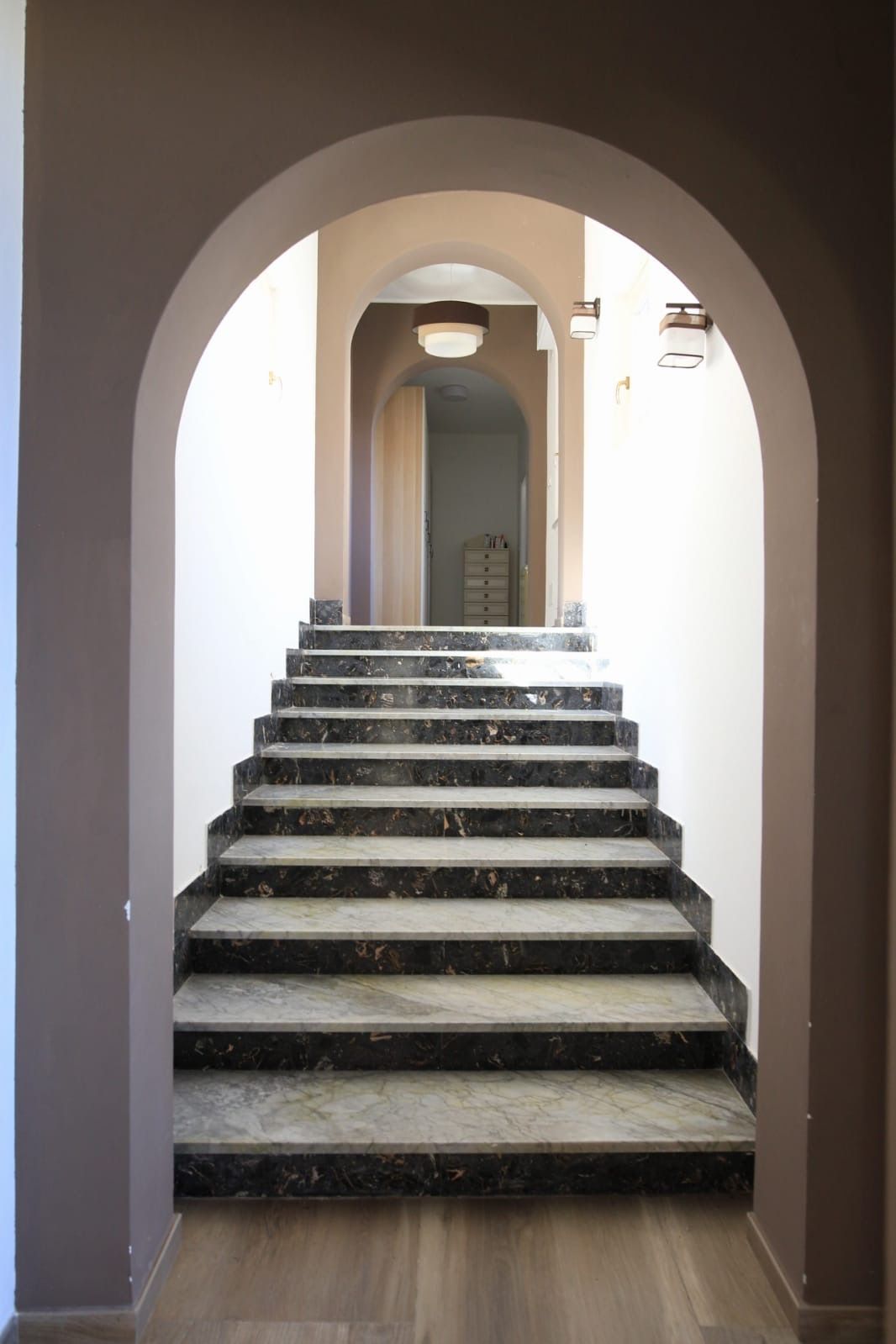 Eine Marmertreppe führt zu einer Tür oben.