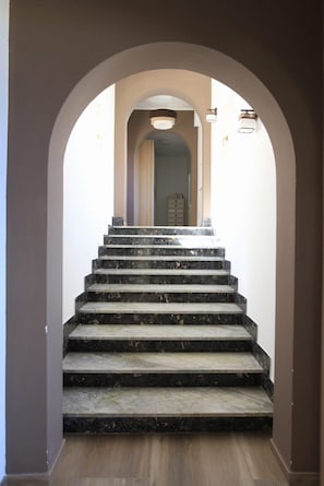 Eine Marmertreppe führt zu einer Tür oben.