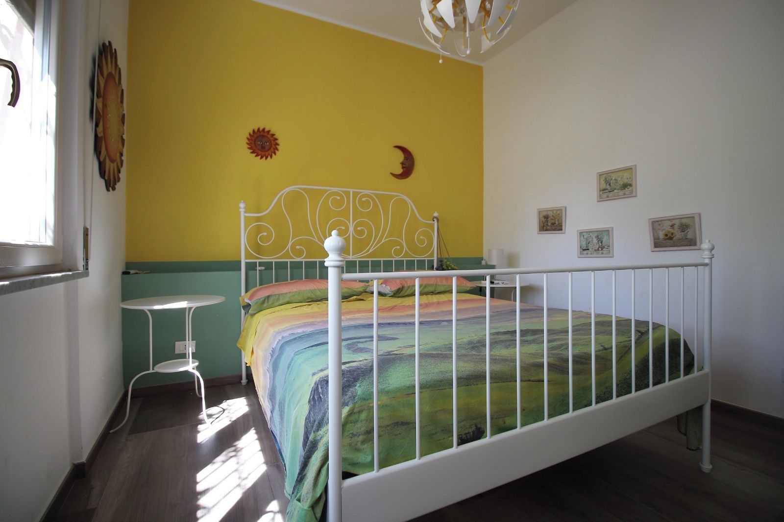 Une pièce avec un lit, une petite table et une fenêtre.