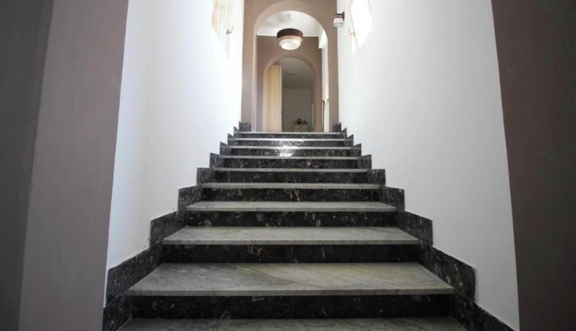 A staircase with a handrail leading to a landing.