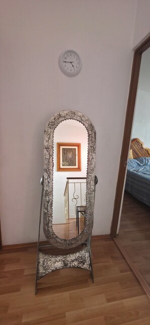 A room with a standing mirror, a clock on the wall, and a bed with a blue cover. - House 5 minutes from the airport, Santa Fe, industrial area, covered porch, barbecue, and pet. (Lerma de Villada)