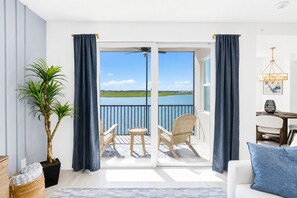 A balcony with a view of a lake, a dining area with a table and chairs, and a potted plant. - Calsua Golf Club 2BR Lakefront Condo Putt In Paradise (Bradenton)