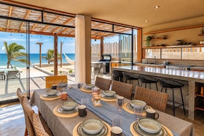 A dining area with a view of the beach, a bar, and a kitchen. - Oceanview Modern home in Organos AmorAmAr LN4 (Organos)