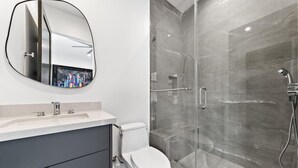 A bathroom with a toilet, sink, and a shower with a glass door. - Private Guesthouse · Walk to The Grove & LACMA (Los Angeles)