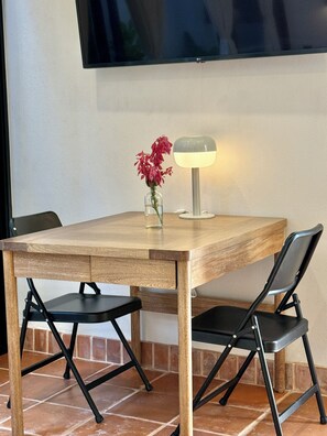 A dining table with chairs, a vase with flowers, and a table lamp.