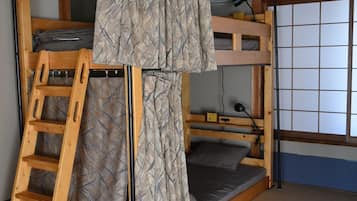 A bunk bed room with a ladder, a ceiling fan, and a window with a grid pattern.