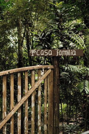 A wooden gate with a sign that reads 'casa familiar' in a lush, green environment. - Beachfront Solar Villa - Private Pool - Surf at Your Door - Osa Peninsula (Puntarenas Province)