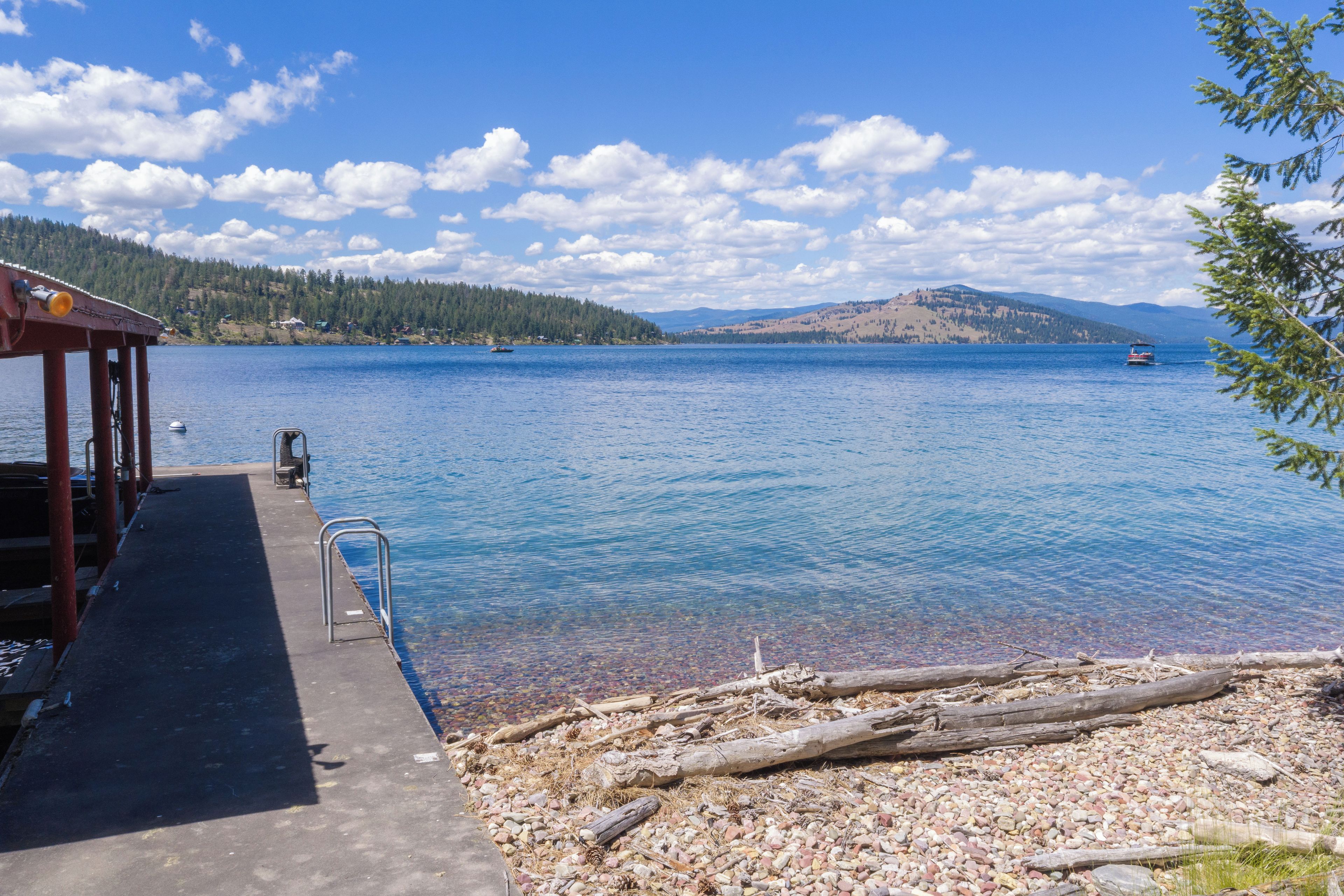 A lakeside dock with a clear view of the water and distant hills.