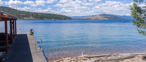 A lakeside dock with a clear view of the water and distant hills.