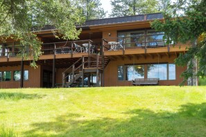 Ein mehrstöckiges Gebäude mit Balkon und Sitzgelegenheit im Freien.