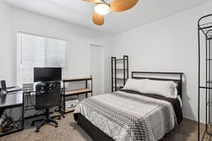 A bedroom with a bed, a desk with a computer, a chair, and a ceiling fan. - Scottsdale Getaway | 2BR/2BA | Relax & Unwind (Scottsdale)