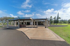 Un espacio al aire libre techado con un letrero que indica Turtle Bay, una tienda de golf y un bar-restaurante.