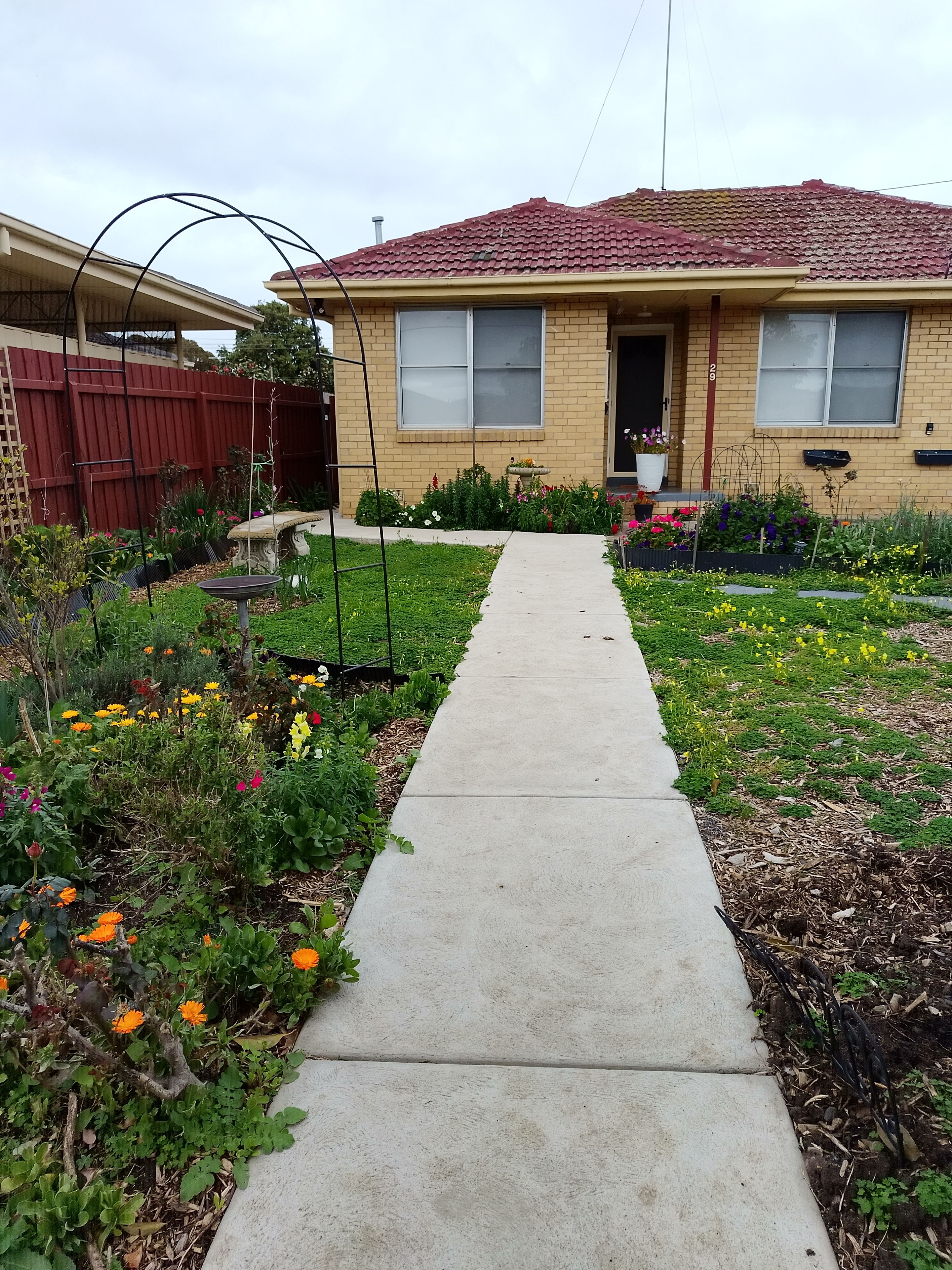 A residential house with a concrete pathway leading to the front door.