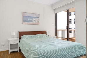 A bedroom with a bed, two bedside tables with lamps, a painting on the wall, and a balcony with a railing. - Private flat, spacious and central in Sydney (Sydney)