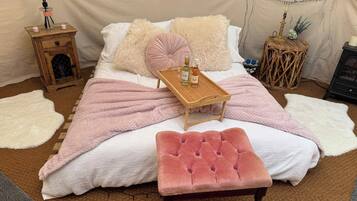 Un dormitorio acogedor con cama, mesita de noche, un pequeño armario de madera y un adorno en la pared.
