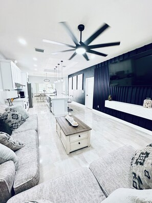 Una sala de estar moderna con un sofá, una mesa de centro y una televisión.