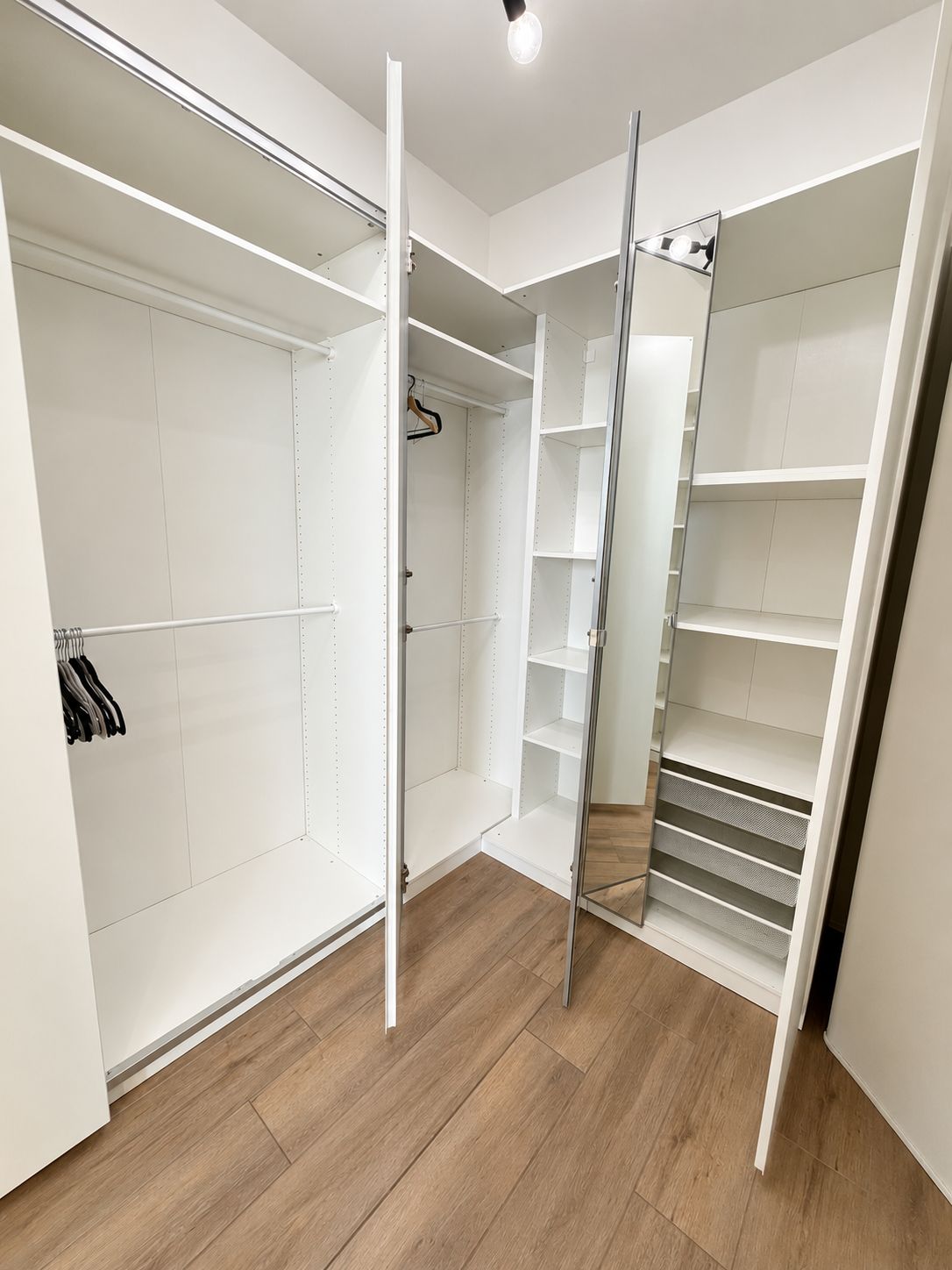 A walk-in closet with open doors, revealing shelves and hanging space.