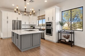 A modern kitchen with a large island, stainless steel appliances, and a view of the outdoors. - New! Luxury Private Desert Retreat + 4 Beds + Hot Tub + Gated + 5 Horse Stalls (Scottsdale)