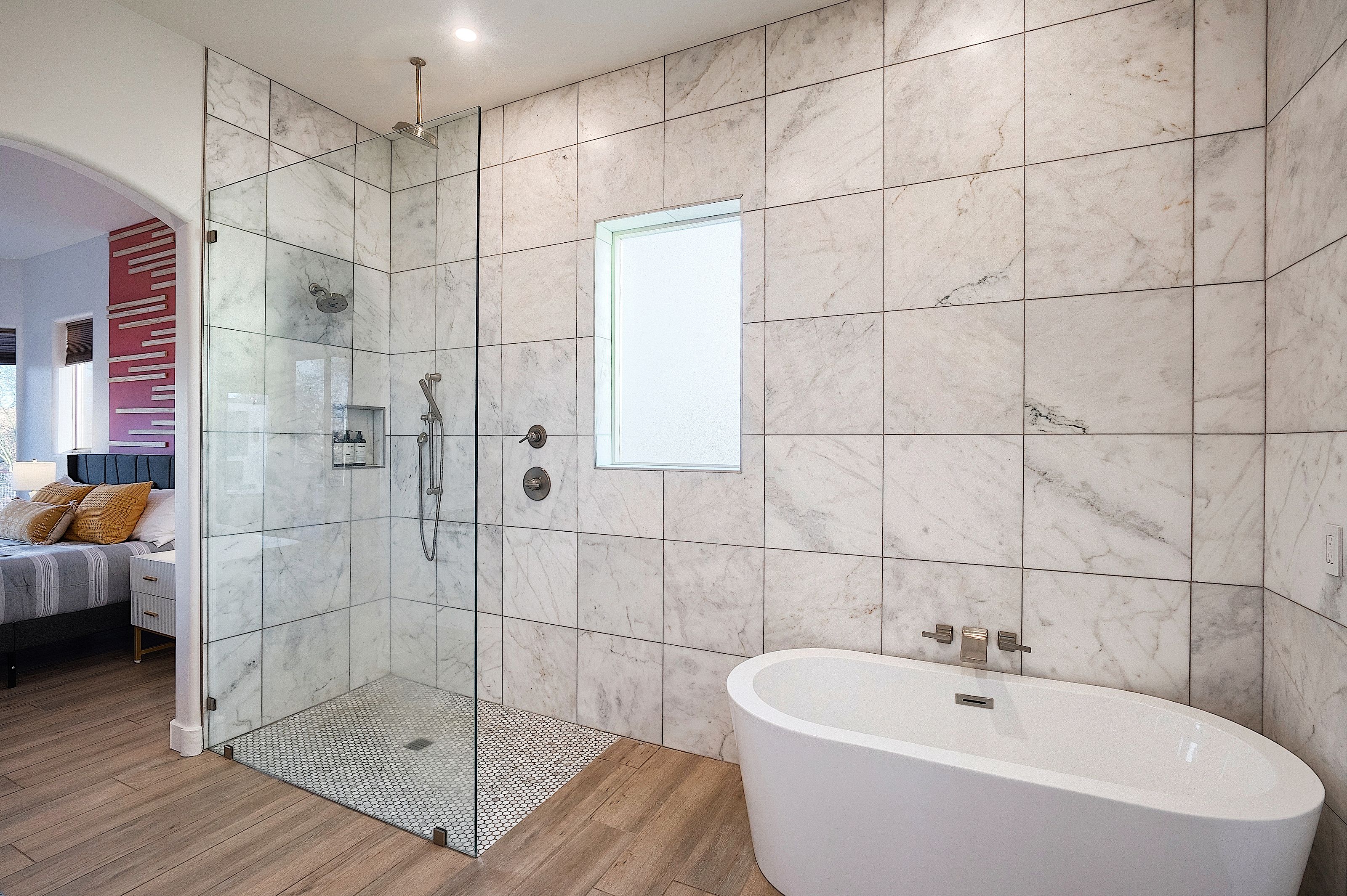 Une salle de bain moderne avec une douche à parois de verre, une baignoire sur pieds et un grand miroir.