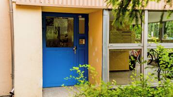 A blue door with a keyhole, a mailbox, and a glass door leading to a room with bicycles inside.