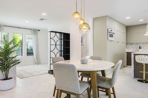 A modern dining area with a round table, four chairs, and pendant lighting. - Welcome to Triton Tiki! W/heated Pool, Located in Cape Coral’s premier 33904 (Cape Coral)