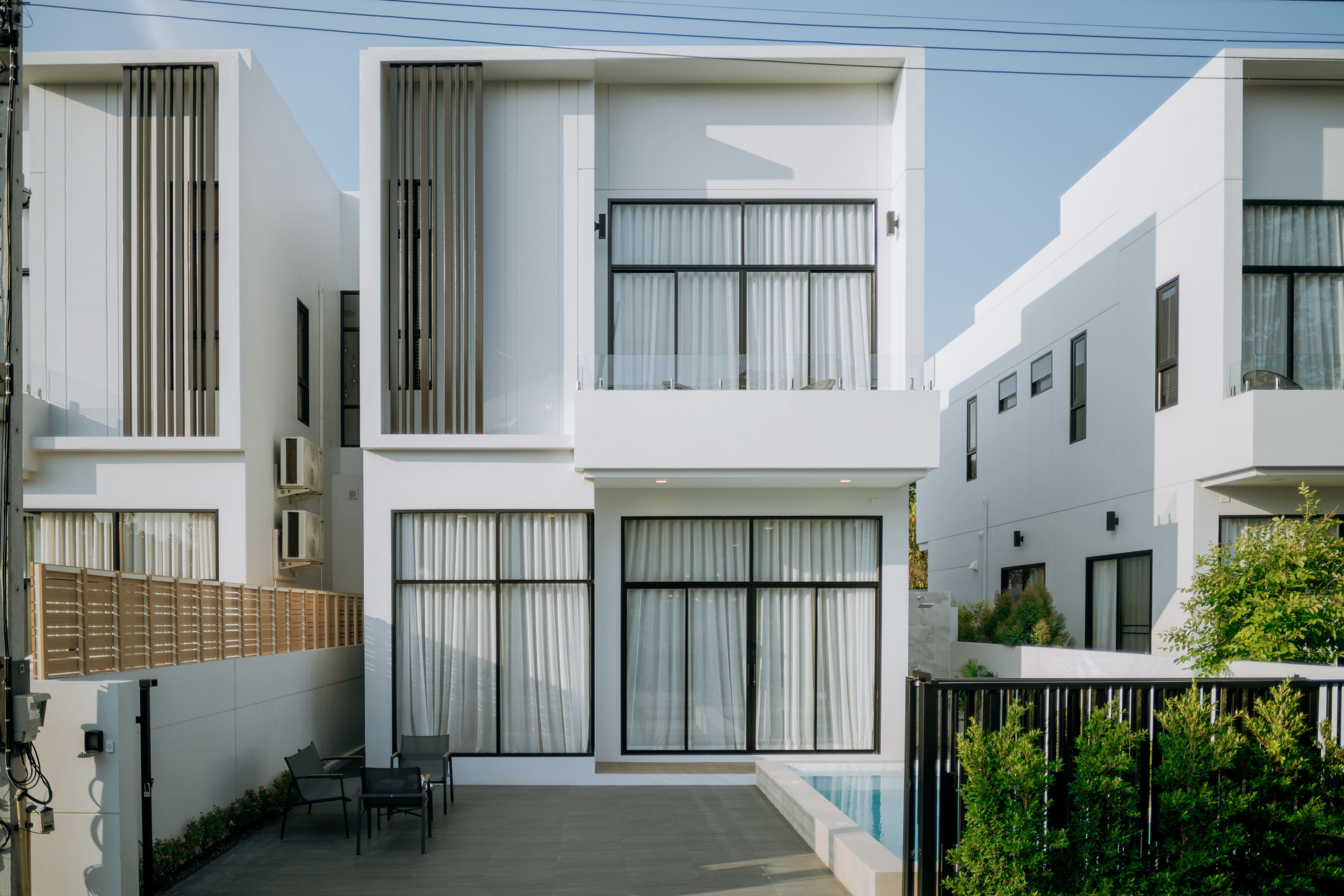 Un moderno edificio residencial de dos pisos con grandes ventanales y techo plano.