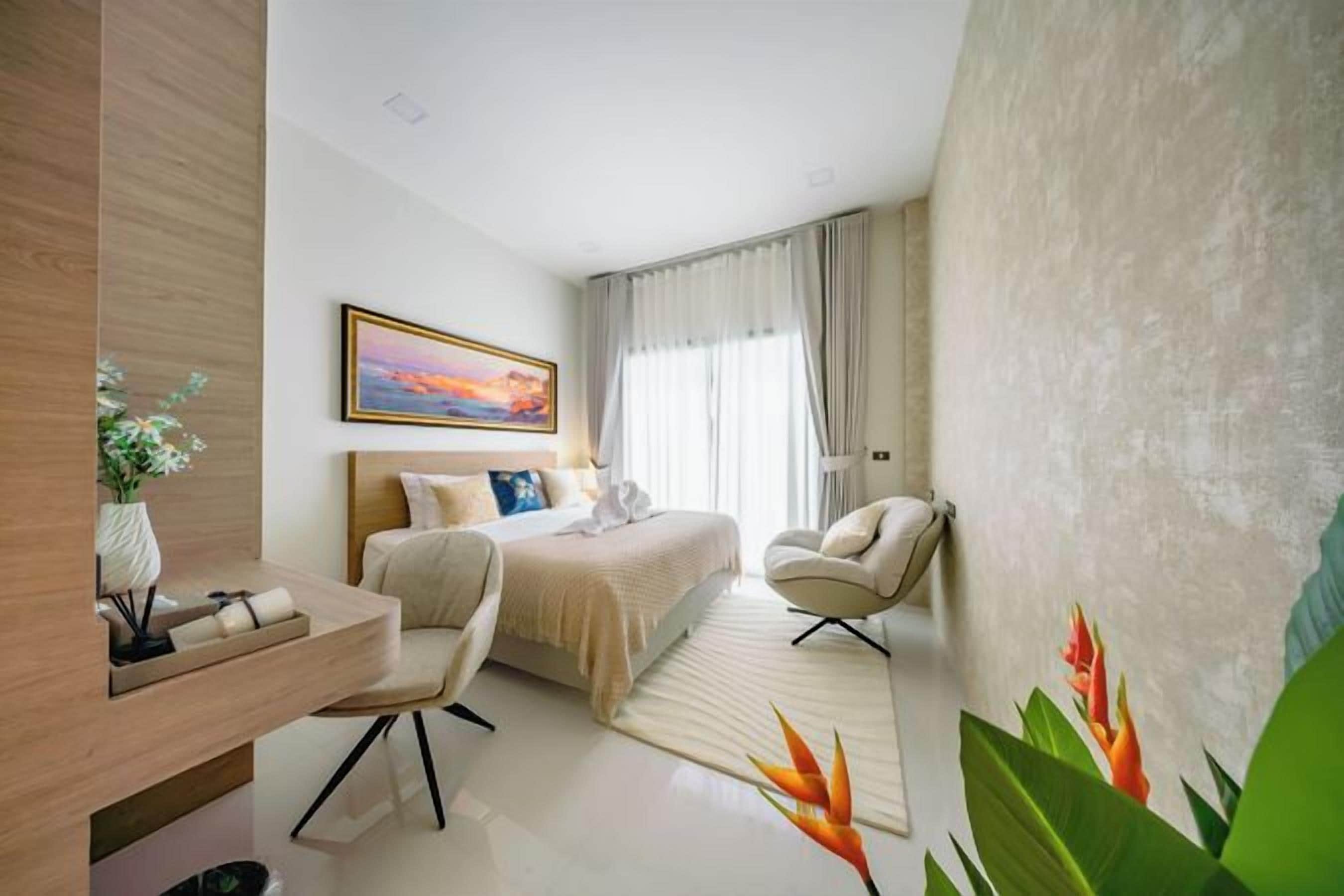 Una habitación de hotel moderna con cama, escritorio, silla y un ventanal grande.
