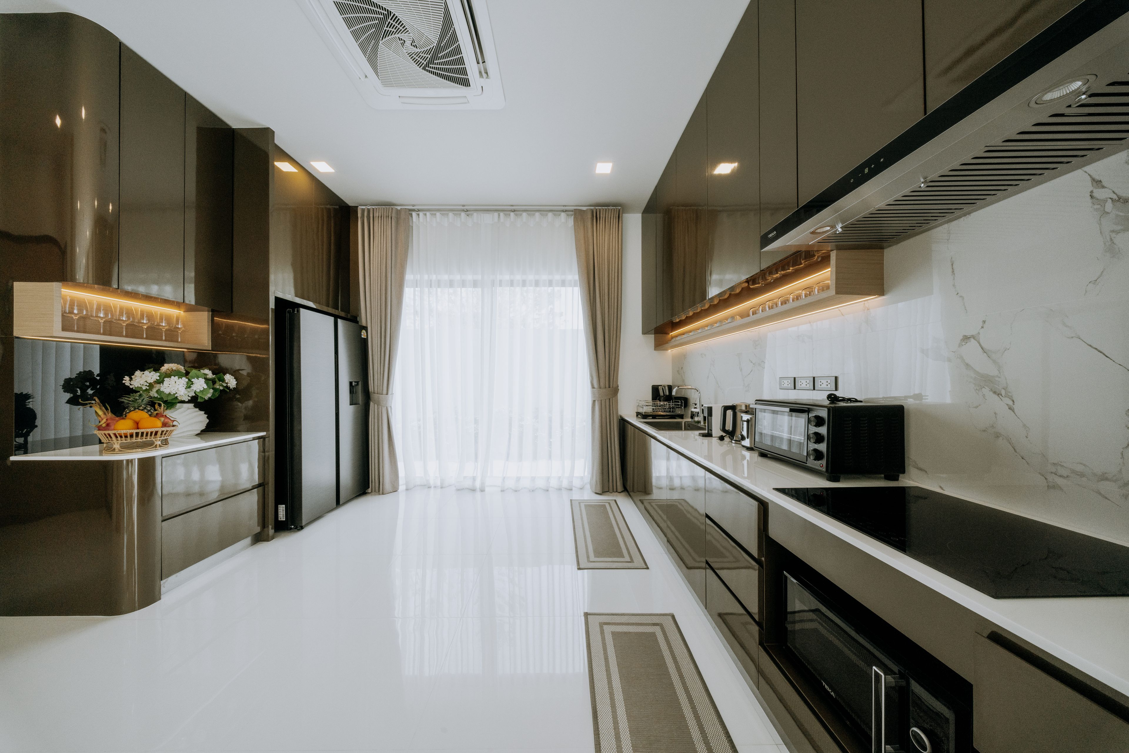A modern kitchen with stainless steel appliances, a marble countertop, and a central island.