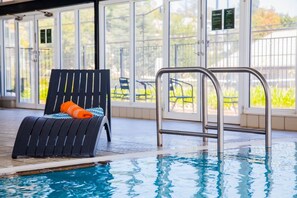 Ein Hallenbad mit Liegestuhl und einer Metallleiter.