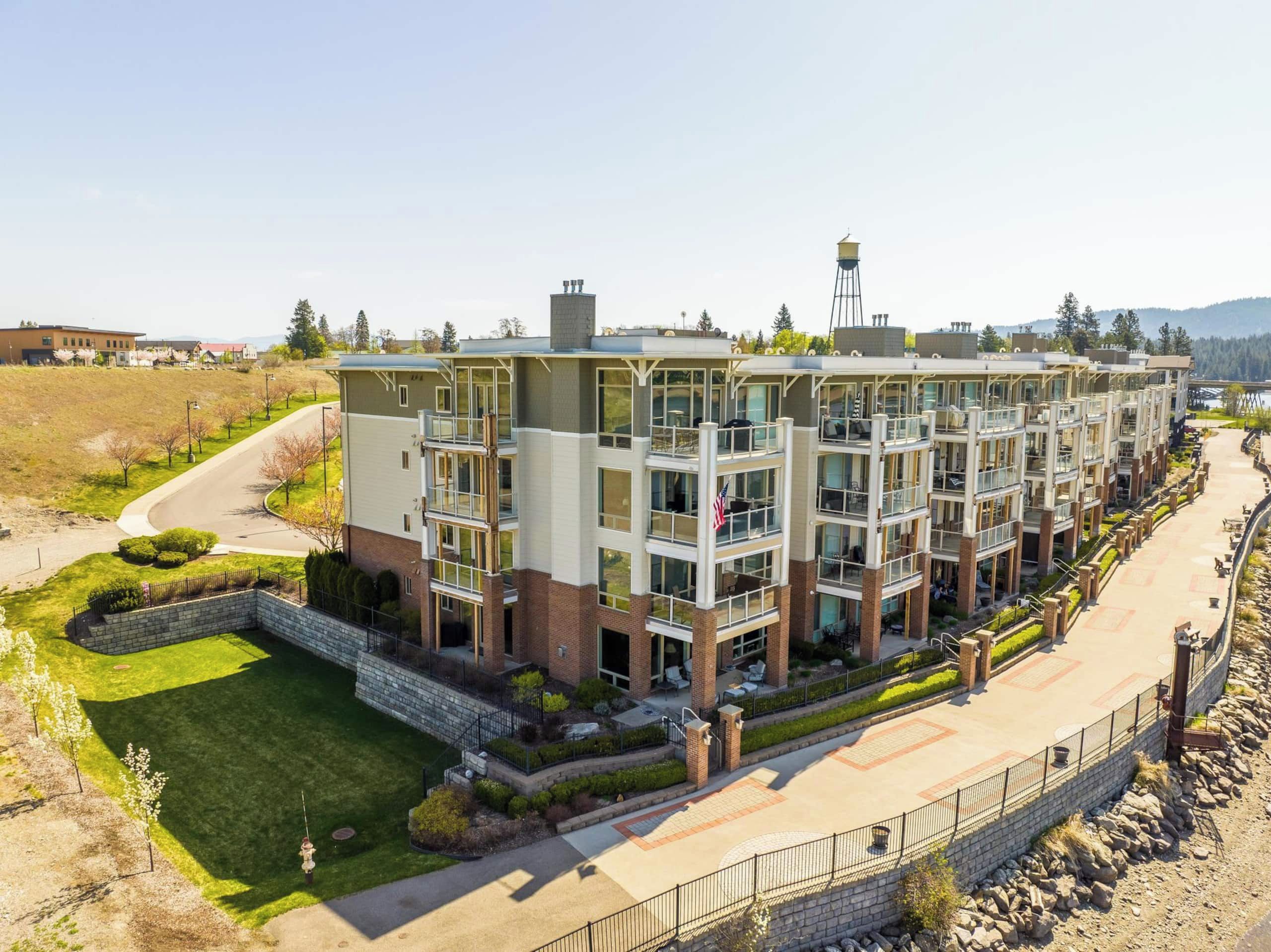 A multi-story residential building with balconies, a landscaped courtyard, and a clear view of the surrounding area.
