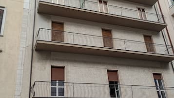 A multi-story building with balconies, a garage door, and graffiti.