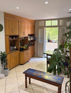A kitchen with wooden cabinets, a dining table, and potted plants.
