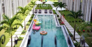 Une piscine équipée de chaises longues et de jeux gonflables.
