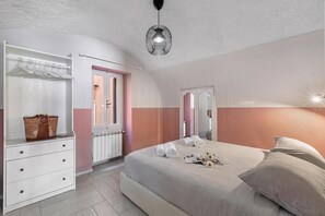 A bedroom with a bed, a dresser, a wardrobe, and a hanging light fixture. - Icardi 2 Casa Di Mattoni, Dolceacqua, Italy (Dolceacqua)