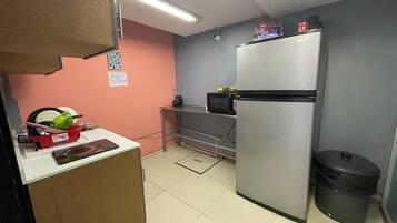 Una cocina compacta con refrigerador, microondas y una pequeña encimera.