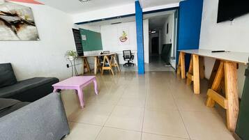 Un interior moderno con un sofá, una mesa rosa y un escritorio de madera.