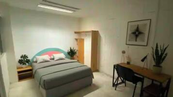 Un dormitorio con una cama, mesitas de noche, un escritorio y una silla.