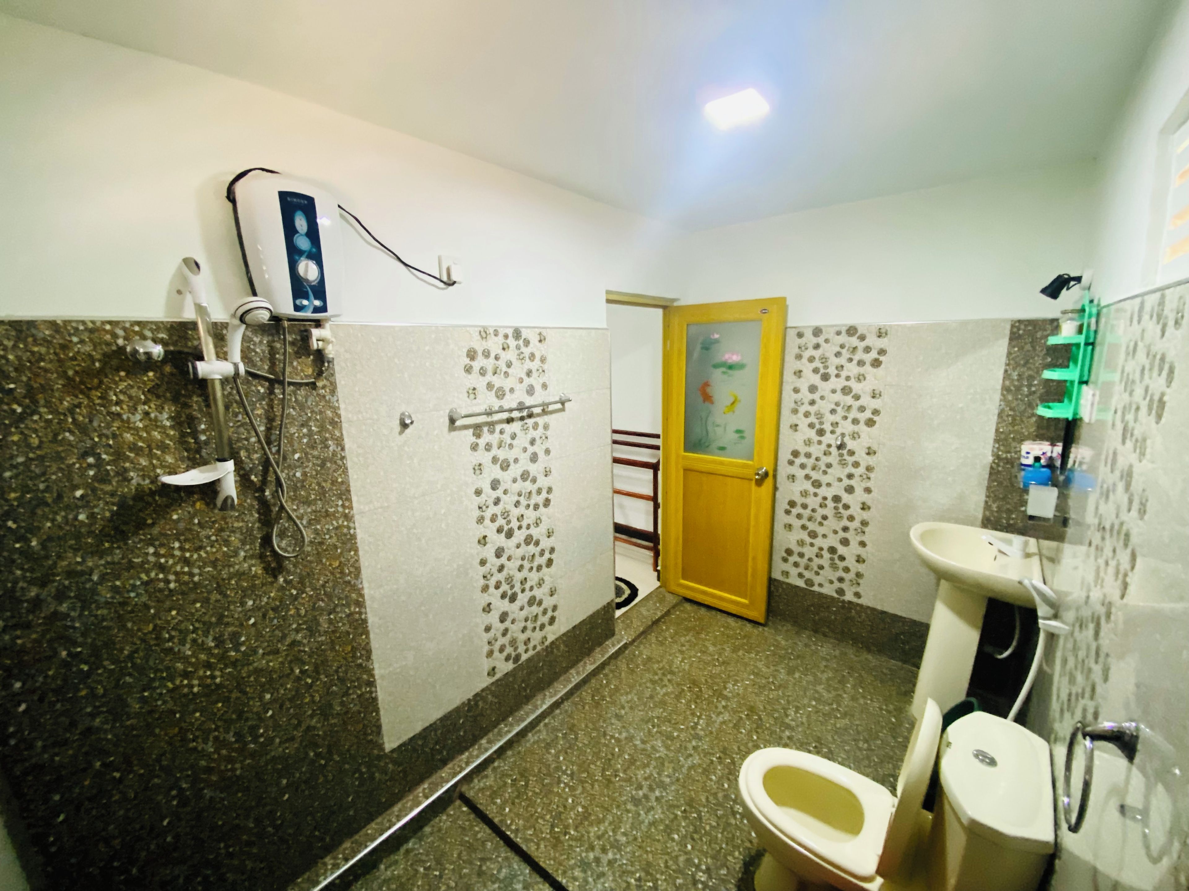A bathroom with a shower, toilet, and sink.