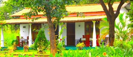 A traditional building with a tiled roof, surrounded by lush greenery and a well-maintained garden.