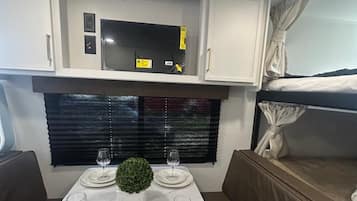 Interni di un camper compatto con angolo ristoro, angolo cottura e zona notte.