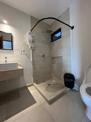 Un baño moderno con ducha, inodoro y lavamanos.
