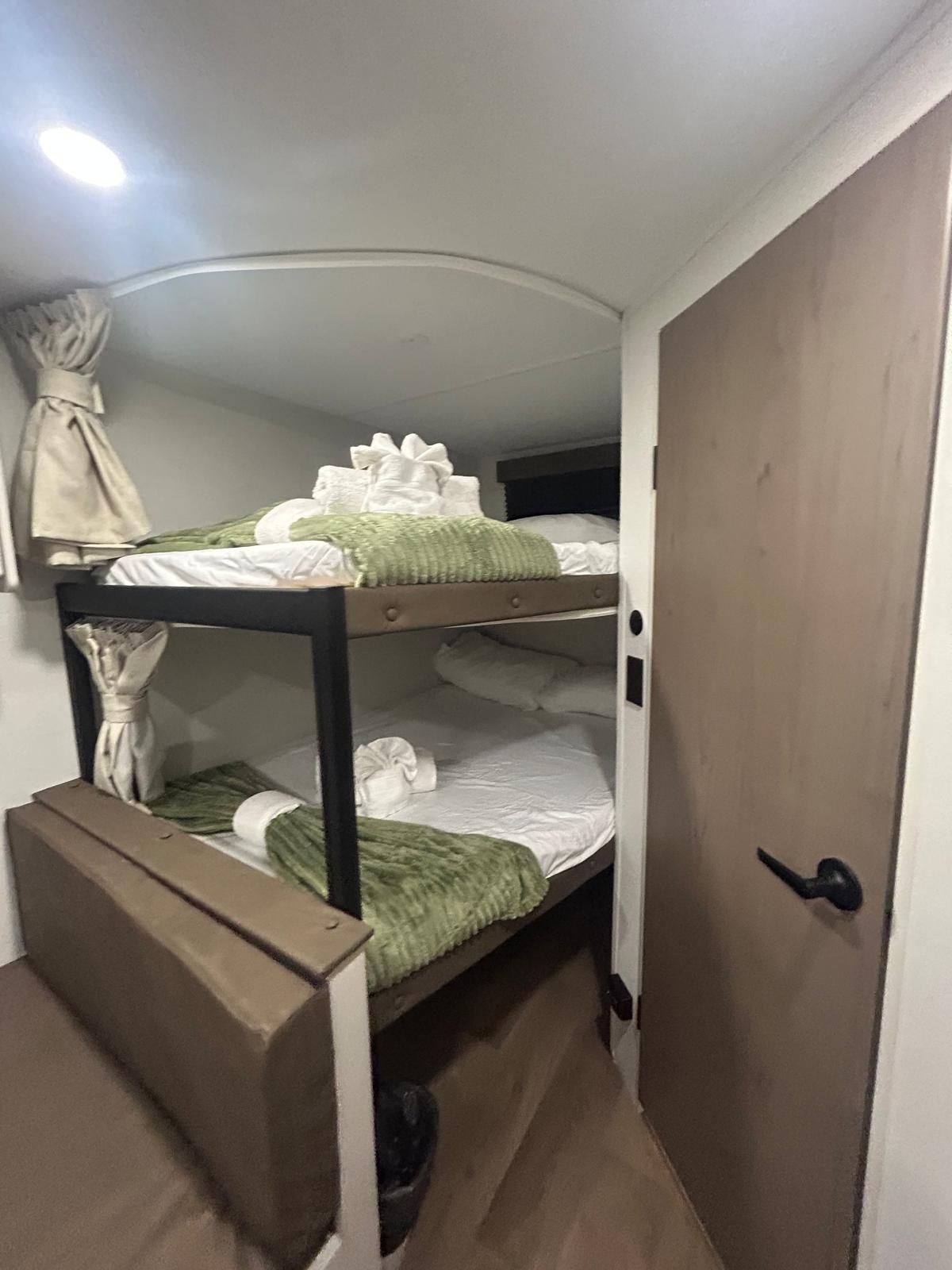 Habitación con literas, puerta y cortina.