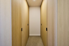 A narrow hallway with wooden doors on either side and a carpeted floor. - Central Te Aro 2BR with Balcony & City Views (Wellington)