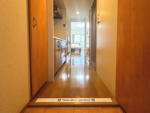 A hotel hallway with a wet floor sign at the entrance. - goom Hotel Hakata Minoshima (Fukuoka City Hakata ku Minoshima)