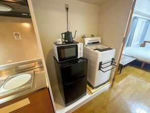 Une petite cuisine équipée d’un four à micro-ondes, d’un grille-pain et d’une machine à café.
